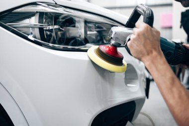 Araba tamiri, oto tamirhanesinde orbital parlatıcıyla el işi. Seçici odak.