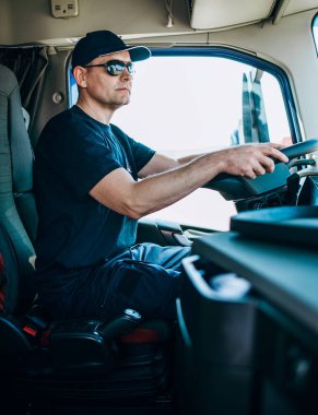 Tecrübeli kamyon şoförü kamyonetinde oturuyor ve yeni bir rota bekliyor.. 