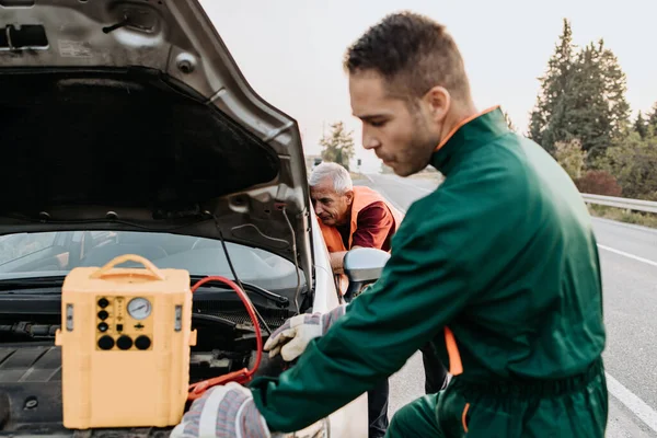 Två Vägassistenter Bogsering Service Försöker Starta Bilen Motor Med Hopp — Stockfoto