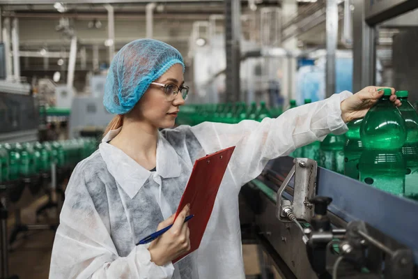 在医疗用品研究和生产工厂工作的从事保护工作的女工在装运前检查蒸馏水罐 检查质量控制 — 图库照片