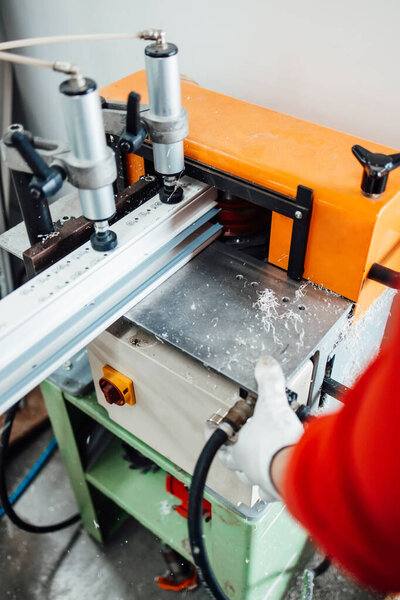 Young male worker assembling products in modern PVC and aluminum doors and windows production factory. 