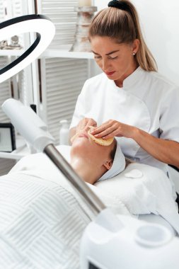 Güzellik salonundaki güzellik tedavileri sırasında genç ve güzel bir kadının derisini temizlemek için pamuk pedleri kullanıyor. Sağlık ve yüz bakımı kavramı. 