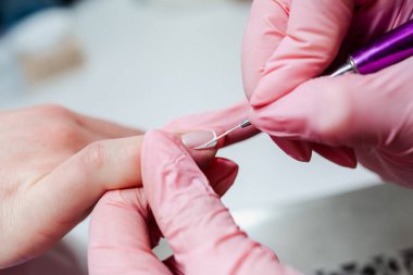 Modern bir güzellik salonunda çalışan profesyonel bir manikürcü. Kadın müşteri kaplıca merkezinde manikür tedavisi görüyor. Yakın çekim..