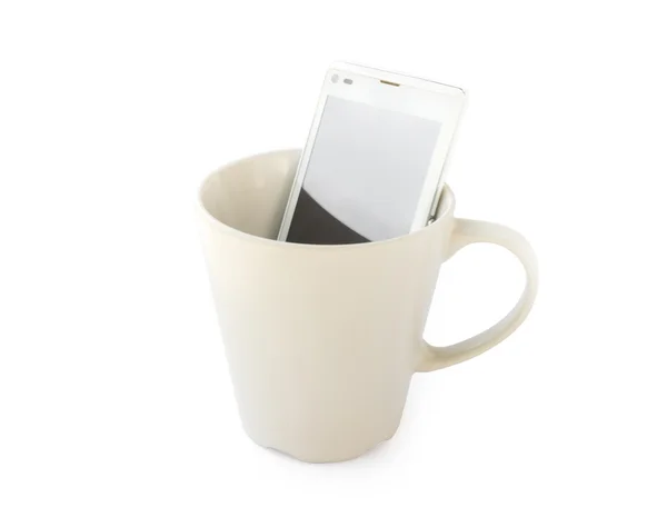 Telefone inteligente em caneca vazia no fundo branco, manhã conceito de tecnologia microfone café da manhã — Fotografia de Stock