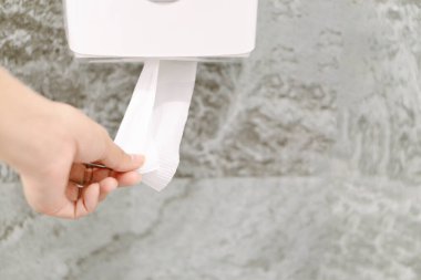 Yakından bir kadın tuvalette beyaz bir mendil topluyor..