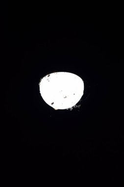 Karanlık gece gökyüzünde parlayan parlak dolunay, yüksek kontrastlı ve minimum çevreyle yakalanmış. Astronomi, gece gökyüzü, uzay, ay yüzeyi, gök cisimleri ve doğal gökyüzü teması için ideal.