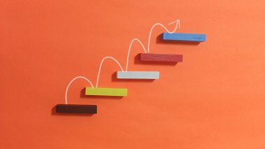 Oklarla yükselen tahta bloklar iş büyümesini ve başarıyı sembolize ediyor.