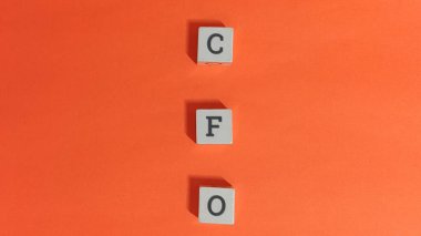 İş için turuncu arka planda tahta küplere mali işler müdürü mektupları.