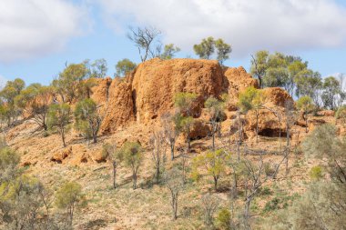 Sığ mağaralar ve derin yarıklar yıpranmış ve aşınmış bir kırmızı kaya oluşumunda Quilpie, Avustralya yakınlarındaki Baldy Top Gözcüsü adı verilen turistik cazibeyi oluşturur..