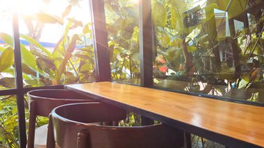 Ahşap tezgah ve Yeşillik Pencere Manzaralı Güneş Işıklı Kafe İçi