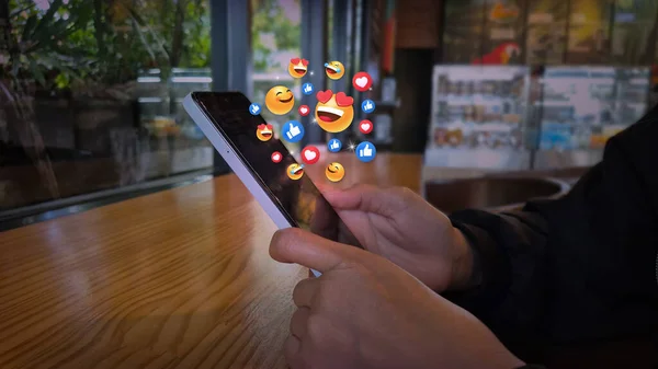 Kafe Ayarlarında Yüzen Sosyal Medya Tepkilerine sahip Akıllı Telefon