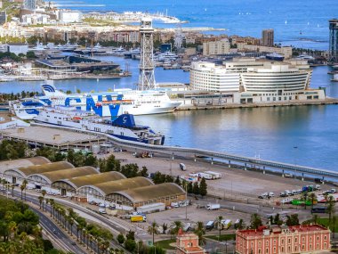 Barselona, İspanya. 5 Ekim 2025. Barselona Limanı 'nın TNY feribotu, Dünya Ticaret Merkezi binası, palmiye çizgili yollar ve yatlarla dolu bir marina ile yakın görüntüsü var.