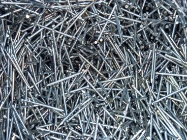 Parlak gümüş çiviler rastgele dağılmış. Metalik doku arka plan, inşaat, DIY, donanım ve sanayiyle ilgili temalar için uygundur.