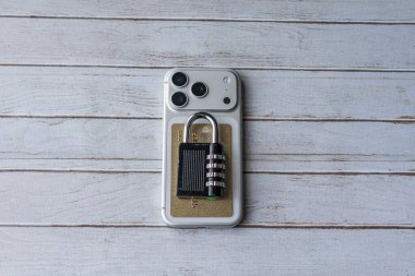 Üstünde kredi kartı ve asma kilit olan akıllı telefonun üst görüntüsü veri gizliliğini, dijital güvenliği ve siber korumayı simgeliyor..