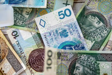 50, 100 ve 200 PLN banknotları da dahil olmak üzere karışık Polonya zloti banknotları. Renkli bir para arka planında düzenlenmiş..