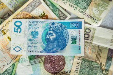 50 Polonyalı zloti banknotunu renkli para arkaplanı oluşturan karışık PLN banknotlarının üzerine yerleştirin.