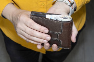 Polonya 'nın zloti banknotlarıyla dolu deri bir cüzdan tutan eller mali tasarruf bütçesini ve kişisel para yönetimini simgeliyor..