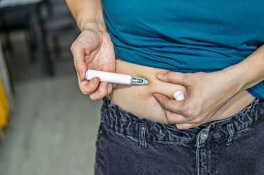 Kendi kendine enjeksiyon, iğne, karın enjeksiyonu, sağlık hizmeti, tıbbi cihaz, ev tedavisi, kişisel sağlık, vücut bakımı, ağırlık yönetimi konsepti, sağlık yaşam tarzı, kapanış, eller, karın bakımı, günlük rutin sağlık hizmetleri, modern sağlık hizmetleri,