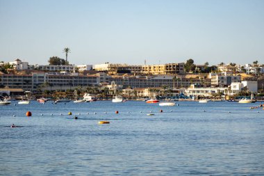 Kızıl Deniz, Mısır. 10 Ocak 2026. Sakin deniz suyuna demirlemiş turist tekneleriyle kıyı şeridi, popüler bir Kızıldeniz tatil beldesinde deniz turizmini, deniz seyahatini ve tatil atmosferini gösteriyor..