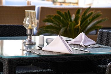 Katlanmış peçeteler ve çatal bıçaklarla hazırlanmış şık bir restoran masası. İyi yemek, konukseverlik ve lüks tatil yeri konsepti, misafirler için hazır, tatil ve seyahat yaşam tarzı.
