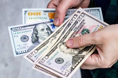 Amerikan doları banknotlarını sayarak ellerinizi yakın tutun. Nakit ödeme, kişisel finans, gelir, harcamalar ve para yönetimi kavramı.