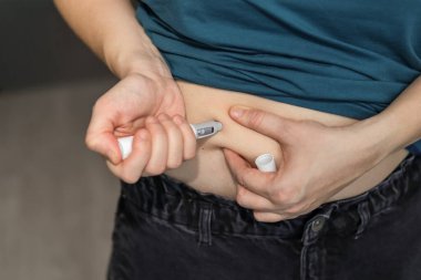 Wroclaw, Poland. January 5, 2026. Close-up of person self-injecting Wegovy weight loss medication into abdomen, illustrating obesity treatment and modern slimming therapy.