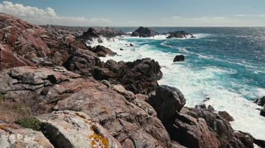 Güçlü Atlantik okyanus dalgaları güneşli bir günde İspanya kıyılarının engebeli granit kayalıklarına çarpıyor. Doğanın ham gücünü ve deniz manzarasının güzelliğini gözler önüne seriyor.