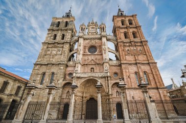 Astorga Katedralleri, İspanya 'nın Castilla y Leon kentindeki Camino de Santiago' da tarihi bir hac anıtı olan mavi gökyüzünün altında yükselen Barok cephesini ve uyumsuz kuleleri süsler.