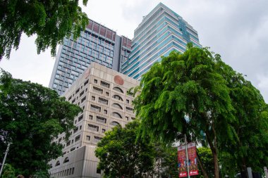 Şehir merkezinde yemyeşil ağaçlarla çevrili modern gökdelenlerin manzarası