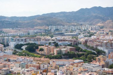 Arka planda dağlar olan bir şehir manzarası.