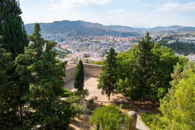 Dağlarla çevrili ve yemyeşil bir şehrin manzarası..