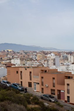 Arkasında binalar ve dağlar olan şehir manzarası.