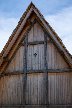 Ahşap bir binanın, ahşap kirişler ve küçük çapraz dekorasyonlu üçgen çatı yapısına sahip, geçitten yakın bir görüntü.