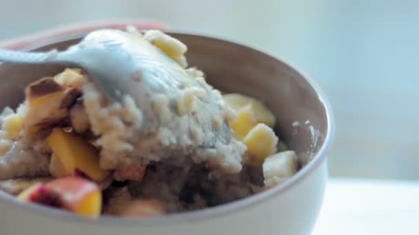 在碗里搅拌与水果燕麦片。健康的饮食 — 图库视频影像