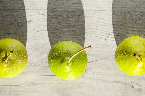 Three juicy green pear with water drops