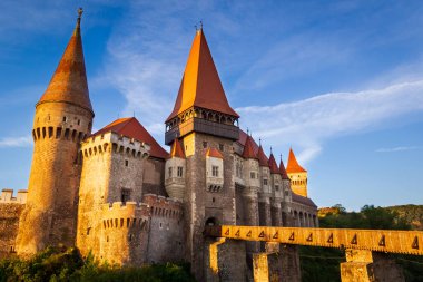 Romanya 'nın Hunedoara kentindeki Corvin Kalesi' nin mavi gökyüzüne karşı güneş doğarken en alt manzarası. Güzel Gotik-Rönesans kalesi, Avrupa 'nın en büyük kalelerinden biri..