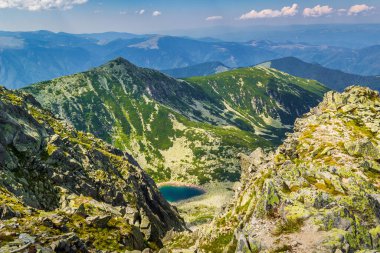 Romanya 'nın Retezat Tepesi' nin 2485 metre tepesinden çarpıcı bir manzara. Karpat Dağları ve açık mavi bir dağ gölü manzarası.