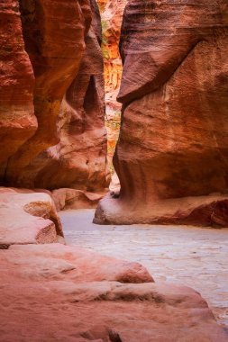 Siq Kanyonu 'nda dar bir yol. Ürdün 'ün ünlü antik Nabataean şehri Petra' da Hazine 'ye giden bir yol. Kırmızı kumtaşından yüksek duvarlar.