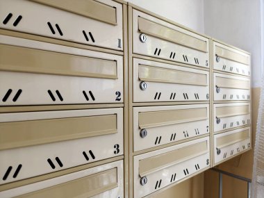 Polonya 'daki eski bir binada posta teslimatı için birden fazla posta kutusu. Bölge sakinleri arasında organize posta dağıtımı. Kilitli metal kaplar.