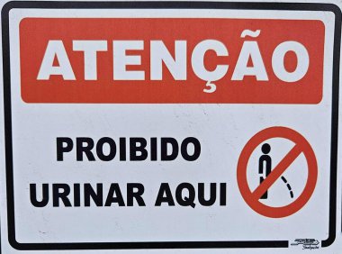 Siyah kenarlı bir beyaz uyarı işareti idrarı yasaklıyor; kırmızı ile 'UYARI', işeyen bir kişinin bir simgesi ile birlikte, yasağı güçlendiriyor, kamu alanlarında saygı ve düzen çağrısında bulunuyor. İşeme İşareti Yok