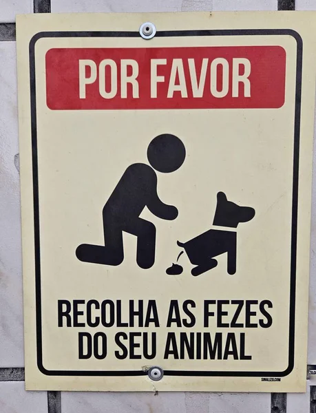 Sahiplerinden evcil hayvan atıklarını toplamalarını isteyin. Görüntü, köpek tarafından çömelmiş, sahiplerinin kamu temizliği ve toplum sağlığı görevlerini vurgulayan kişinin simgesini gösteriyor.