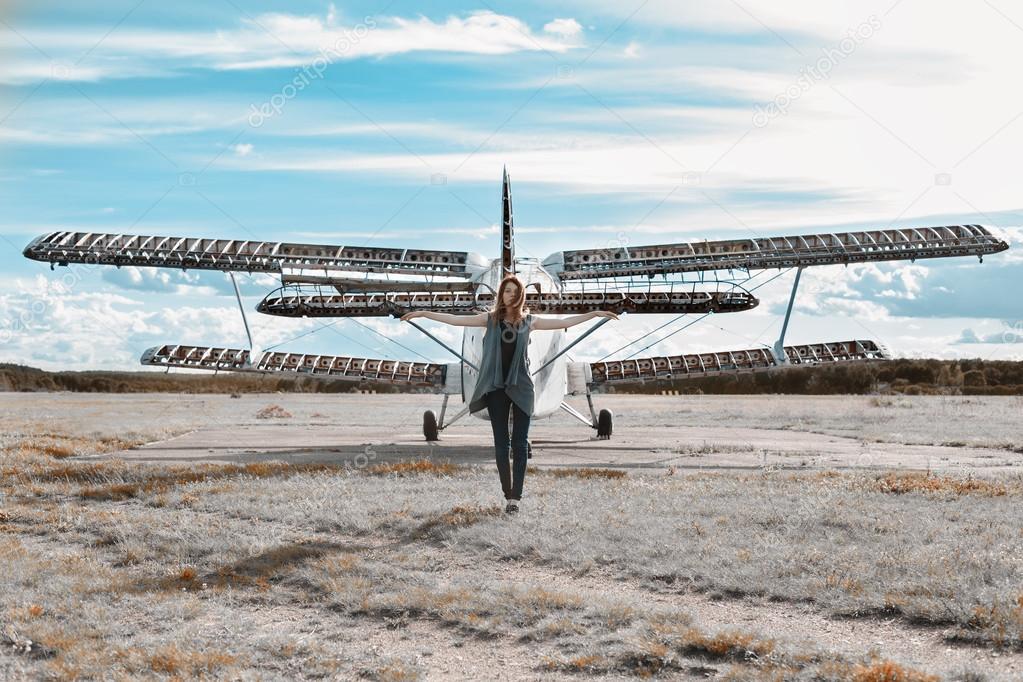 Beautiful lonely girl near the airplane