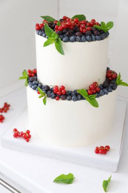 Beyaz kremalı ve böğürtlenli iki kat pasta.