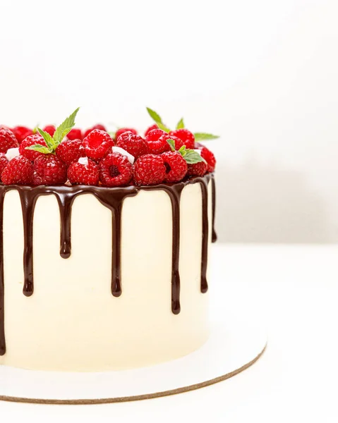 Zomer taart is versierd met witte room en chocolade en frambozen — Stockfoto