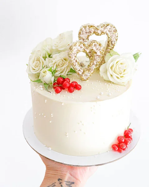 Kuchen für Verliebte mit Blumen und Beeren in Nahaufnahme lizenzfreie Stockbilder