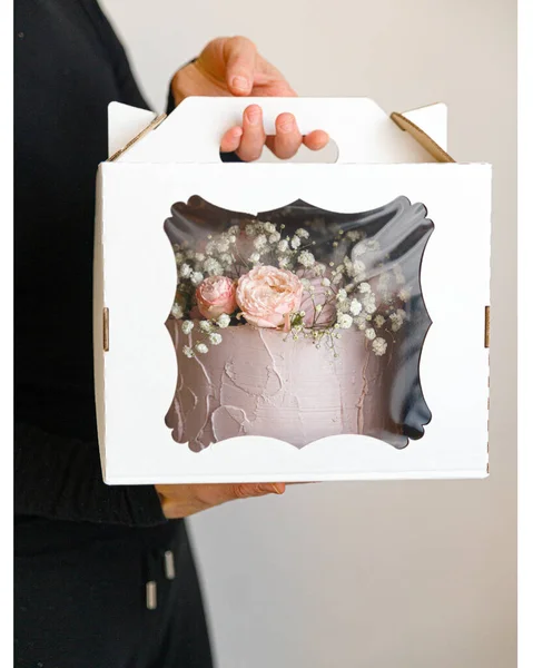 Delicate taart versierd met bloemen in een witte doos Stockfoto