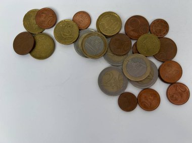 Beyaz arka plana saçılmış farklı değerlerde avro sikkeleri. Para, finans, tasarruf, ekonomi, nakit ödemeler ve günlük harcamalar kavramı. Kopyalama alanı olan üst görünüm.