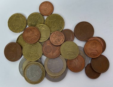 Beyaz arka plana saçılmış farklı değerlerde avro sikkeleri. Para, finans, tasarruf, ekonomi, nakit ödemeler ve günlük harcamalar kavramı. Kopyalama alanı olan üst görünüm.