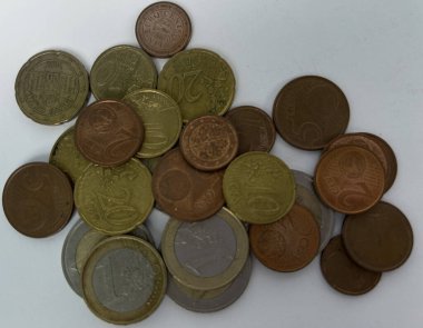 Beyaz arka plana saçılmış farklı değerlerde avro sikkeleri. Para, finans, tasarruf, ekonomi, nakit ödemeler ve günlük harcamalar kavramı. Kopyalama alanı olan üst görünüm.