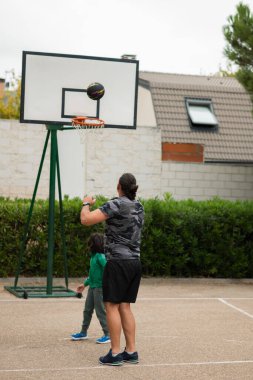 Baba ve çocuk sahada basketbol oynayarak eğleniyorlar.